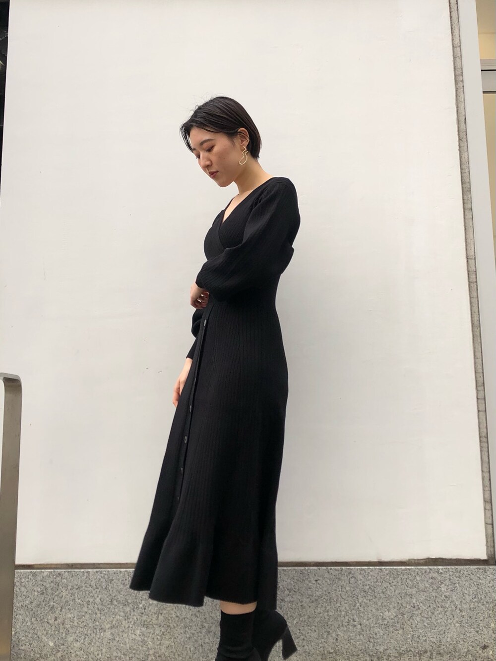 ブラック系のワンピース、ゴールド系のピアス（両耳用）を着用したレディースの冬コーディネートの3枚目の写真