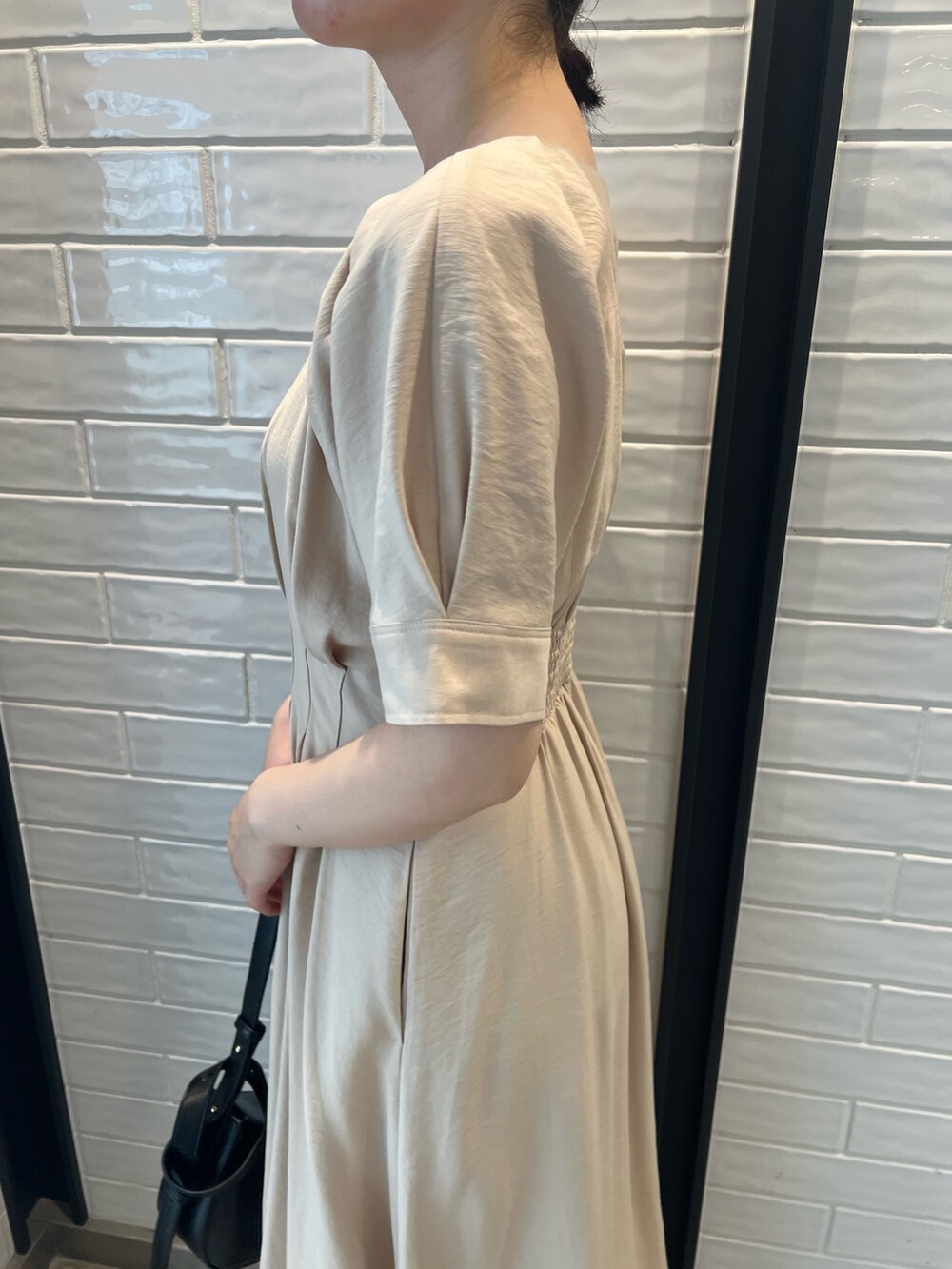 ベージュ系のワンピース、ブラック系のショルダーバッグ、その他のサンダルを着用したレディースの夏コーディネートの8枚目の写真