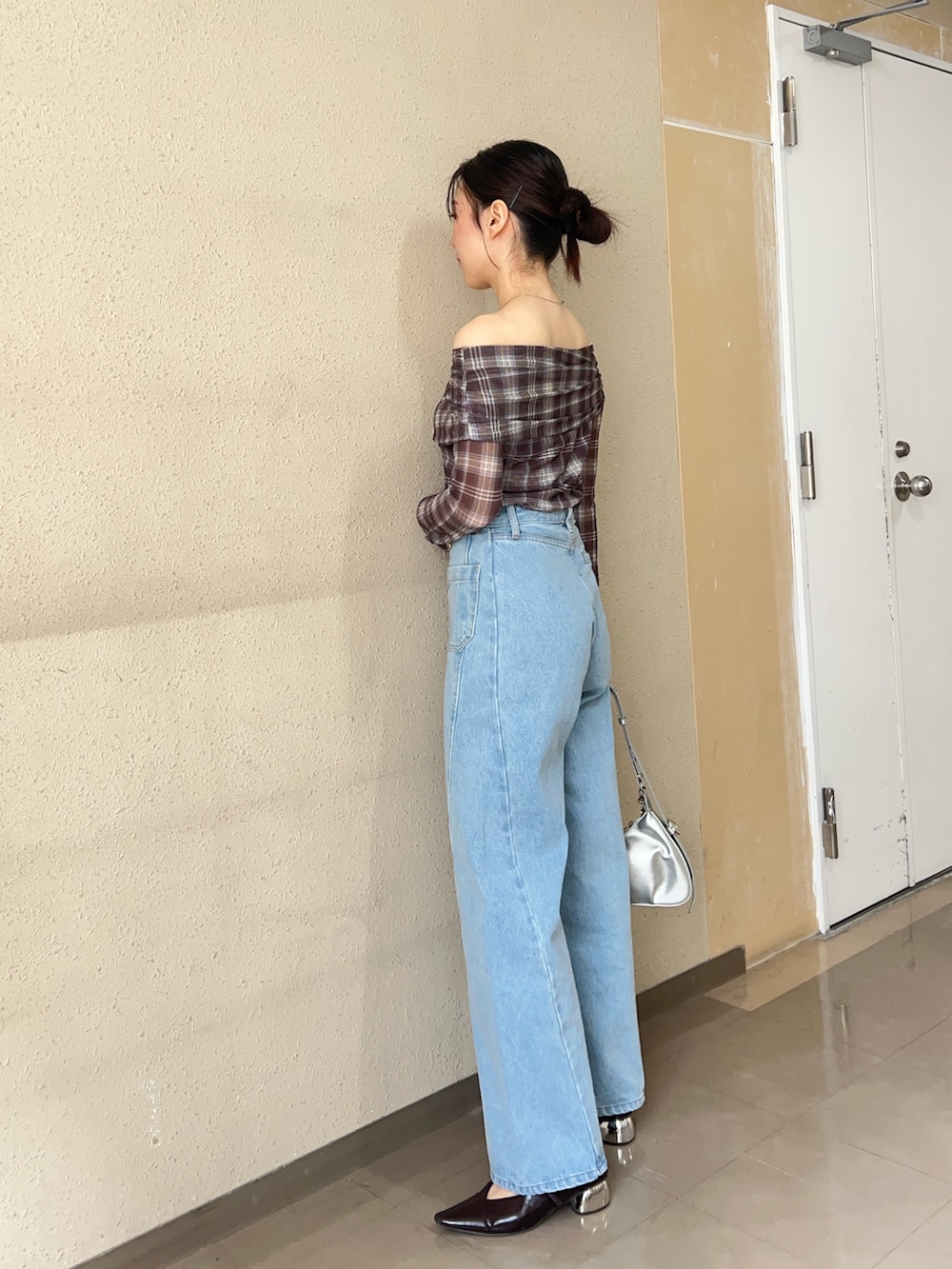 ブラウン系のシャツ/ブラウス、ブルー系のデニムパンツ、ブラック系のパンプスを着用したレディースの春コーディネートの2枚目の写真