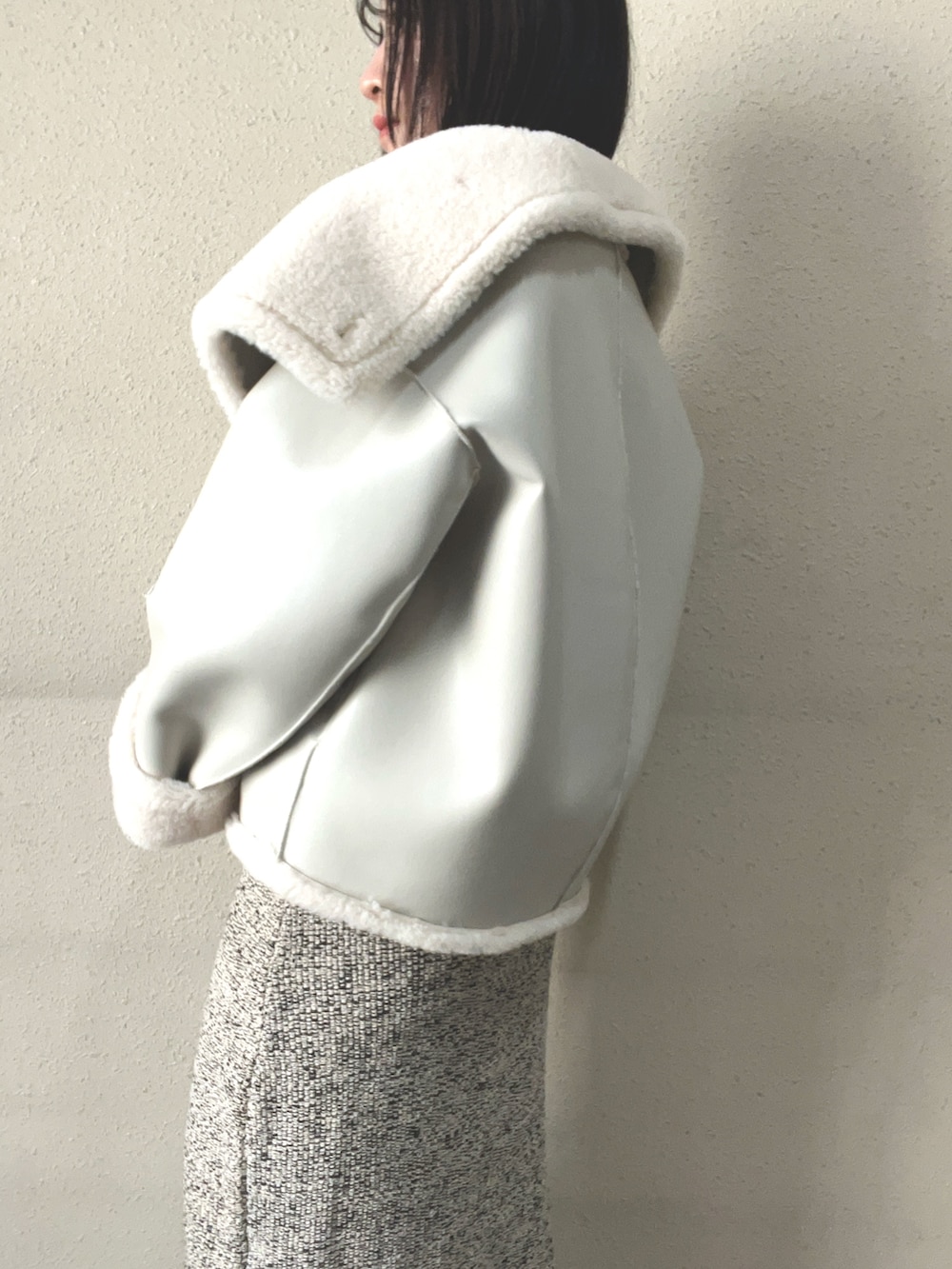 ブラウン系のブーツ、ホワイト系のムートンコート、ベージュ系のジャンパースカートを着用したレディースの秋コーディネートの5枚目の写真