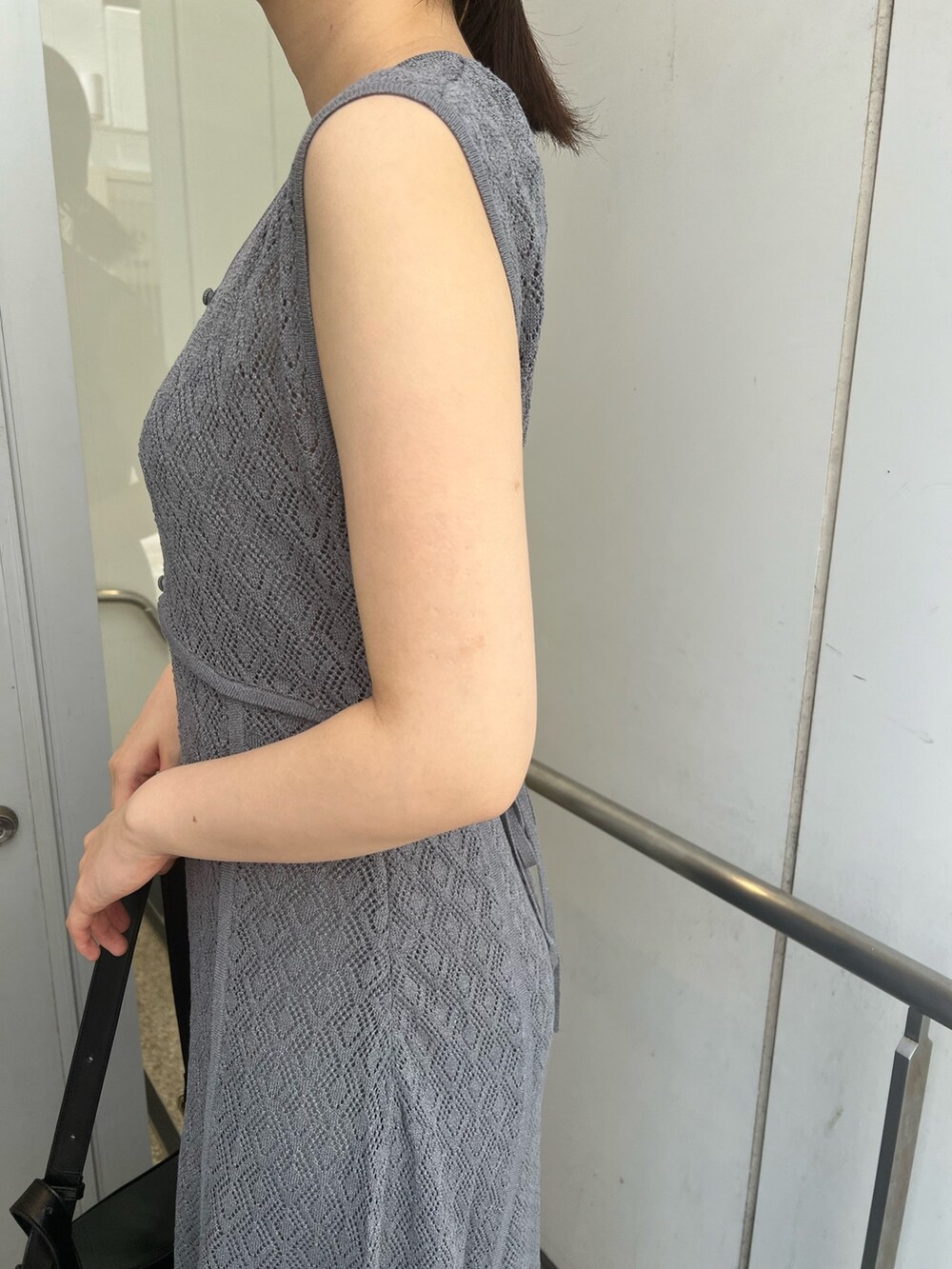 ブラック系のショルダーバッグ、グレー系のワンピースを着用したレディースの夏コーディネートの4枚目の写真