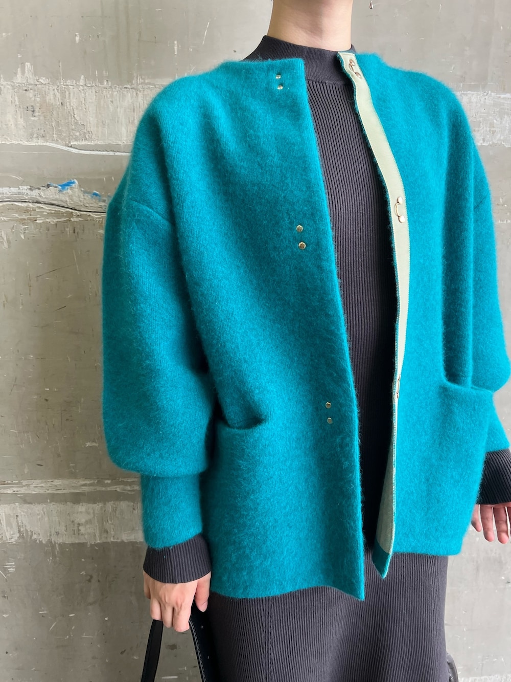 ベージュ系のブーツ、ブルー系のカーディガン/ボレロ、グレー系のワンピースを着用したレディースの秋コーディネートの2枚目の写真