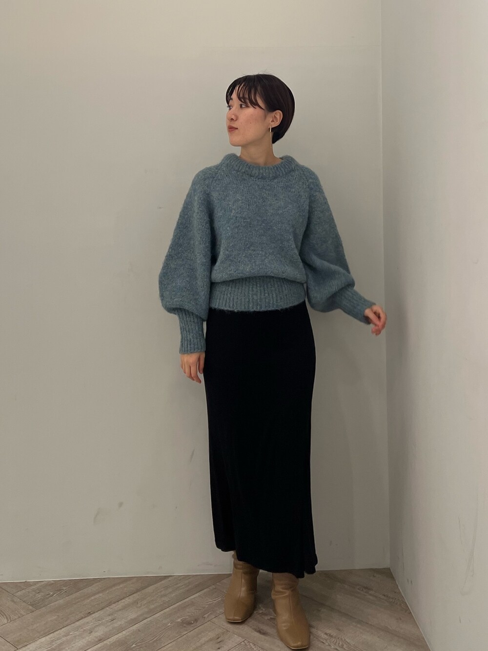 ベージュ系のブーツ、ブラック系のスカート、グリーン系のニット/セーターを着用したレディースの冬コーディネートの7枚目の写真