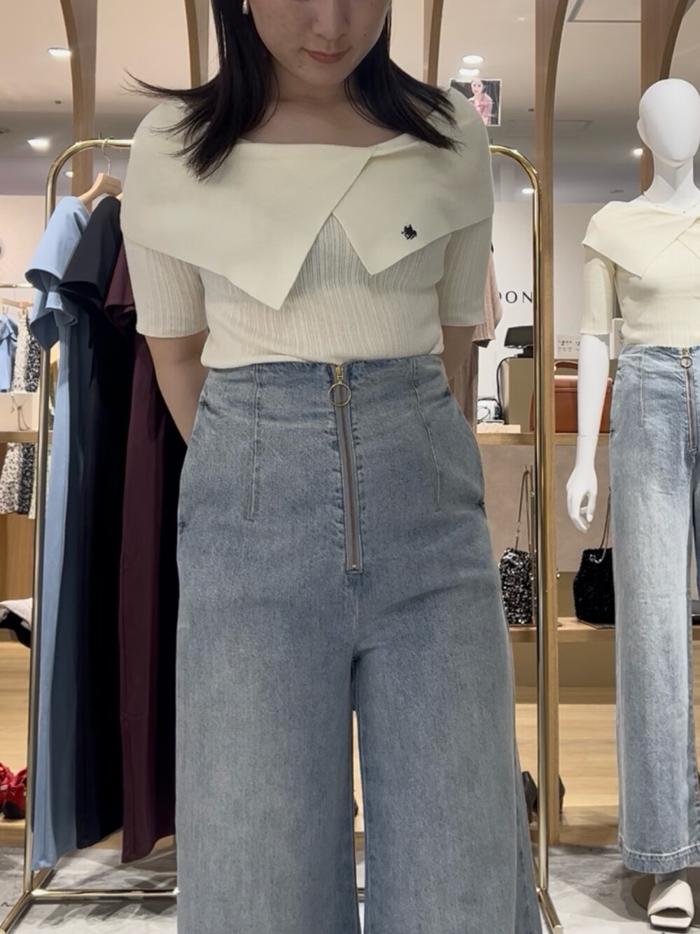 ホワイト系のニット/セーター、ブルー系のデニムパンツ、ブラック系のサンダルを着用したレディースの春コーディネートの4枚目の写真