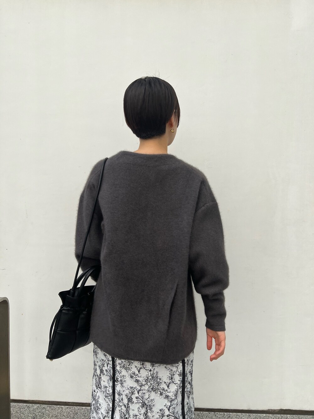 ブラック系のブーツ、ブラック系のスカート、グレー系のカーディガン/ボレロを着用したレディースの秋コーディネートの4枚目の写真