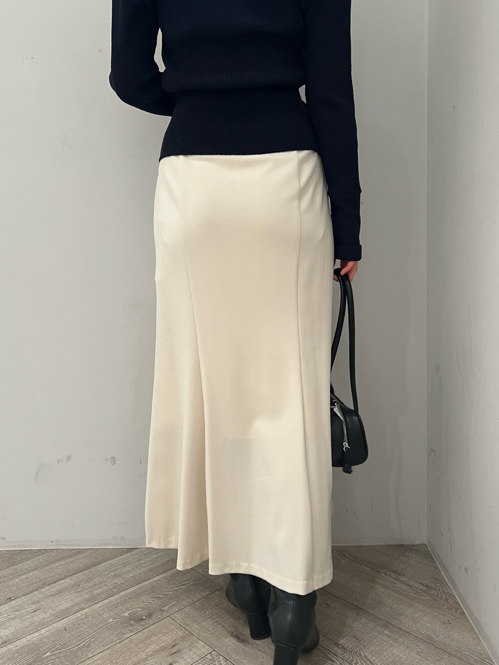 ブルー系のアンサンブル、ホワイト系のスカートを着用したレディースの冬コーディネートの7枚目の写真