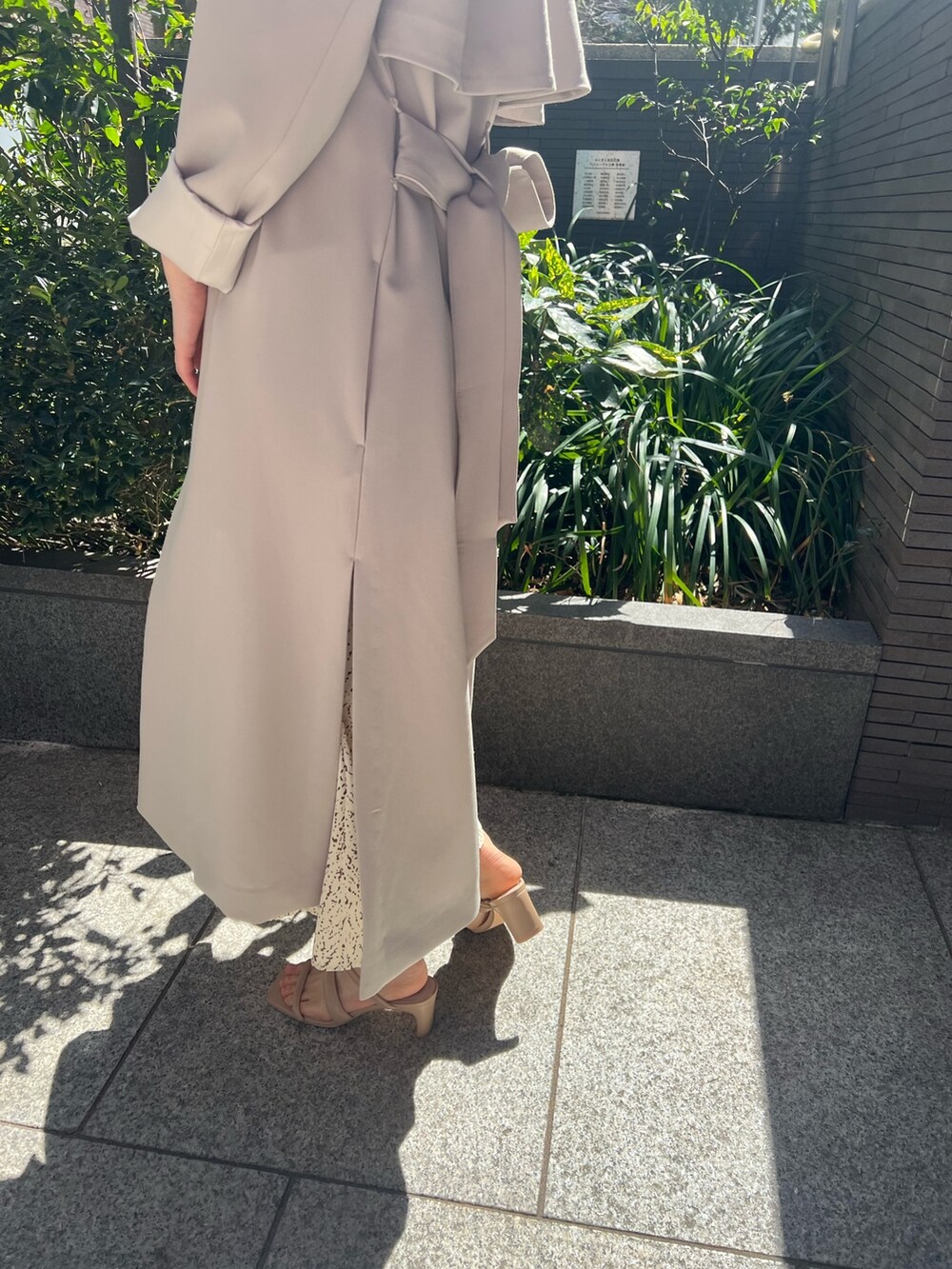 ホワイト系のハンドバッグ、ベージュ系のサンダル、ホワイト系のワンピースを着用したレディースの春コーディネートの5枚目の写真