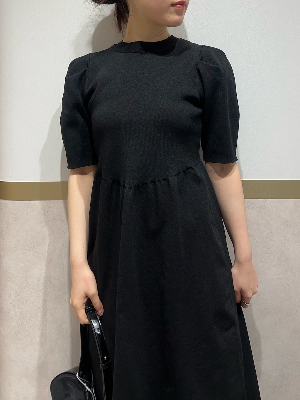 ブラック系のワンピース、ブラウン系のスニーカーを着用したレディースの春コーディネートの4枚目の写真