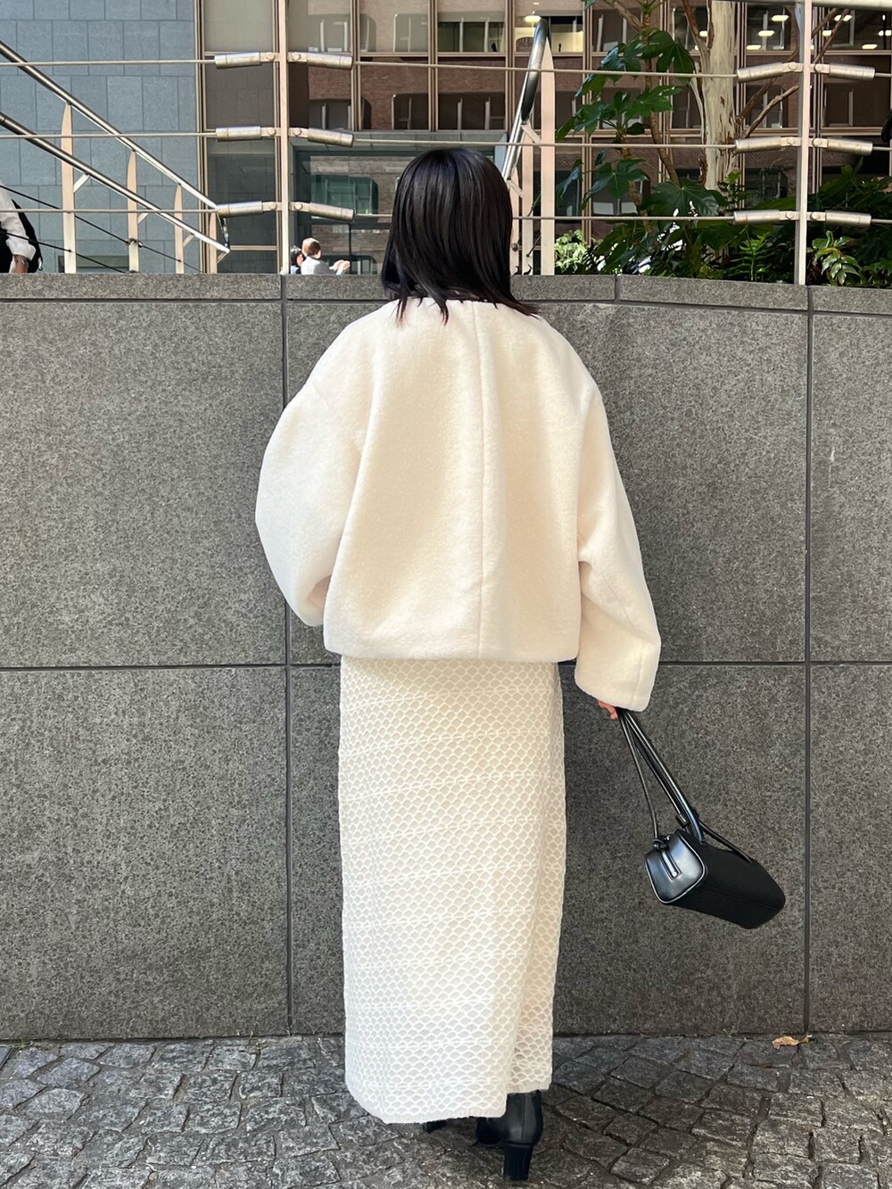 ホワイト系のブルゾン、ホワイト系のワンピース、ブラック系のブーツを着用したレディースの秋コーディネートの2枚目の写真