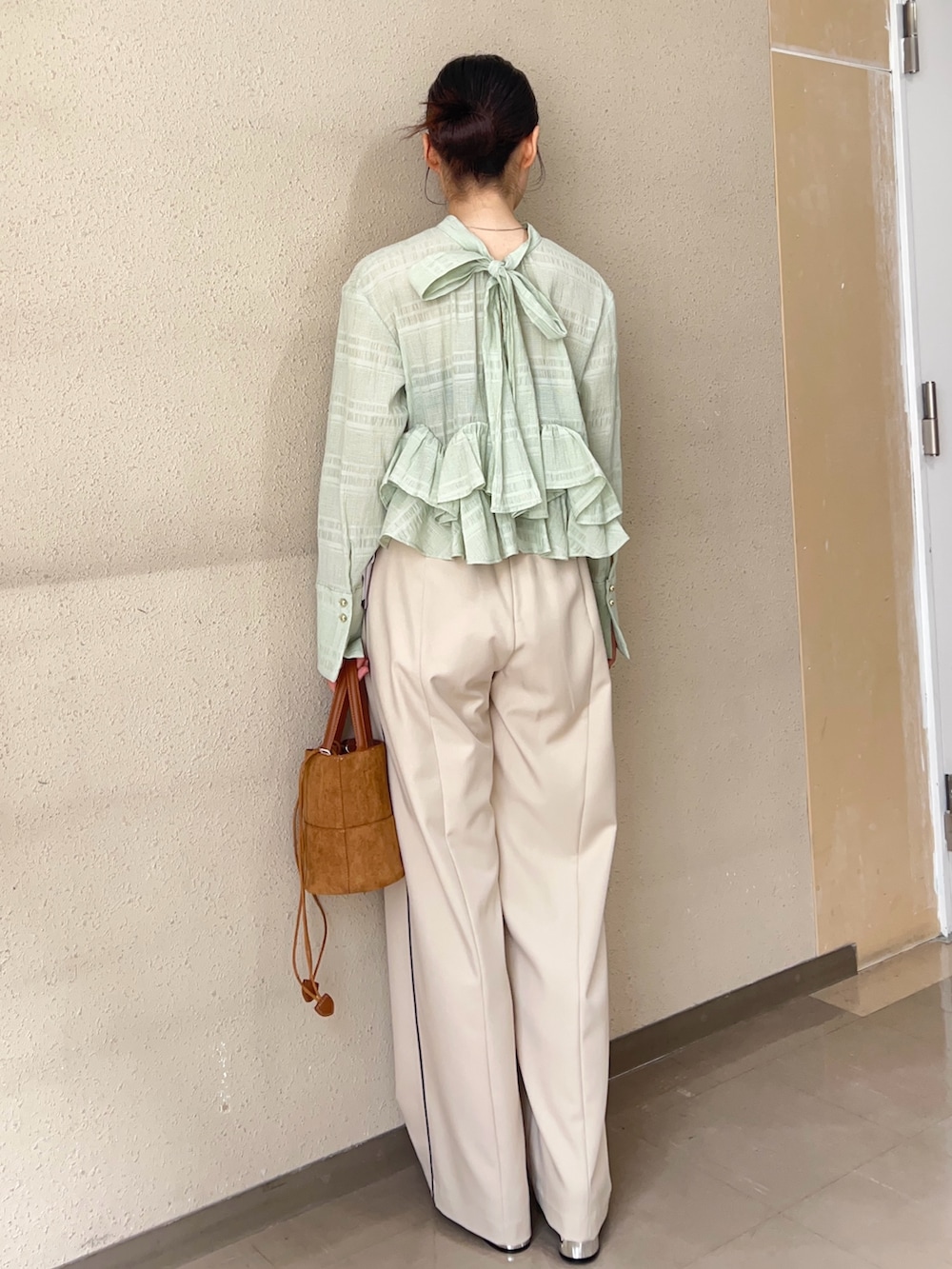ベージュ系のその他パンツ、グリーン系のシャツ/ブラウス、ブラック系のパンプスを着用したレディースの春コーディネートの3枚目の写真
