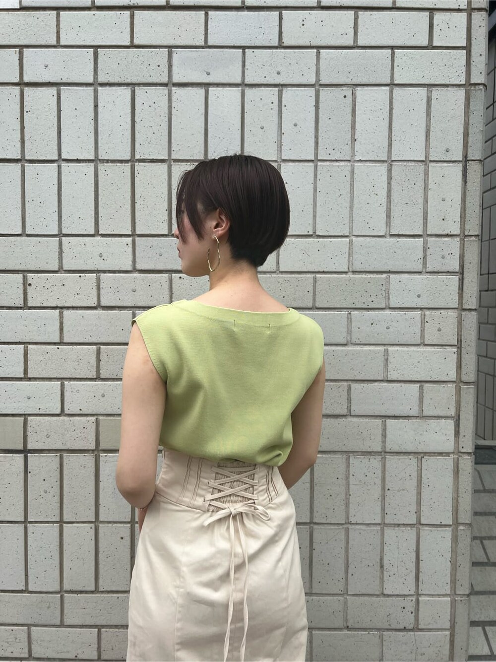 ホワイト系のハンドバッグ、グリーン系のサンダル、ホワイト系のスカートを着用したレディースの春コーディネートの6枚目の写真