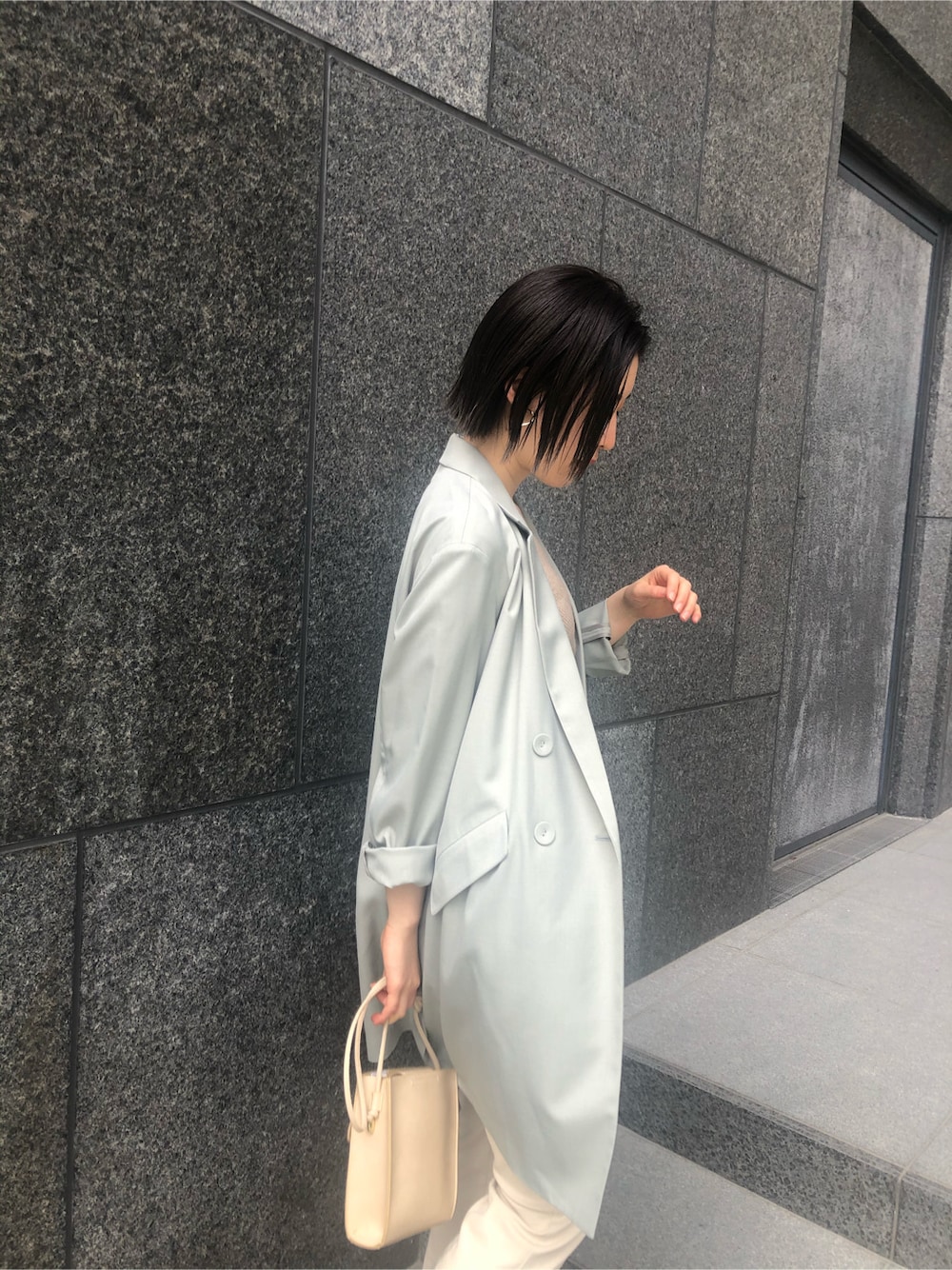 ホワイト系のその他パンツ、ホワイト系のサンダル、ベージュ系のハンドバッグを着用したレディースの春コーディネートの2枚目の写真