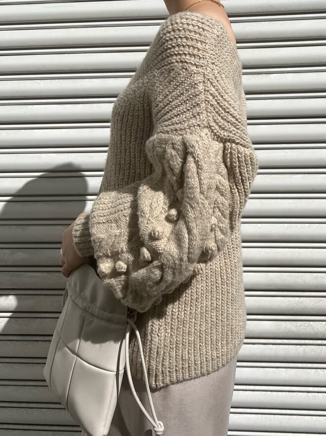 ベージュ系のブーツ、ホワイト系のニット/セーター、グレー系のスカートを着用したレディースの秋コーディネートの8枚目の写真