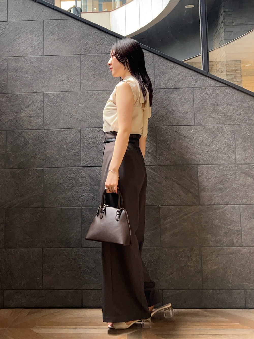 ホワイト系のシャツ/ブラウス、グレー系のその他パンツ、ブラウン系のボストンバッグを着用したレディースの夏コーディネートの2枚目の写真