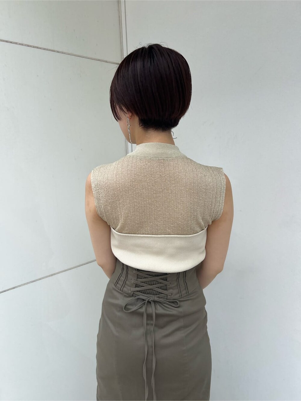 グリーン系のサンダル、ベージュ系のスカート、ホワイト系のニット/セーターを着用したレディースの夏コーディネートの5枚目の写真