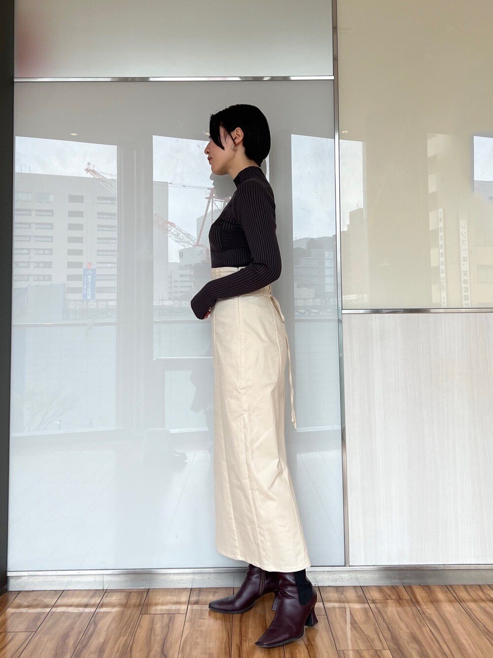 ホワイト系のスカート、グレー系のカーディガン/ボレロ、グレー系のニット/セーターを着用したレディースの冬コーディネートの3枚目の写真