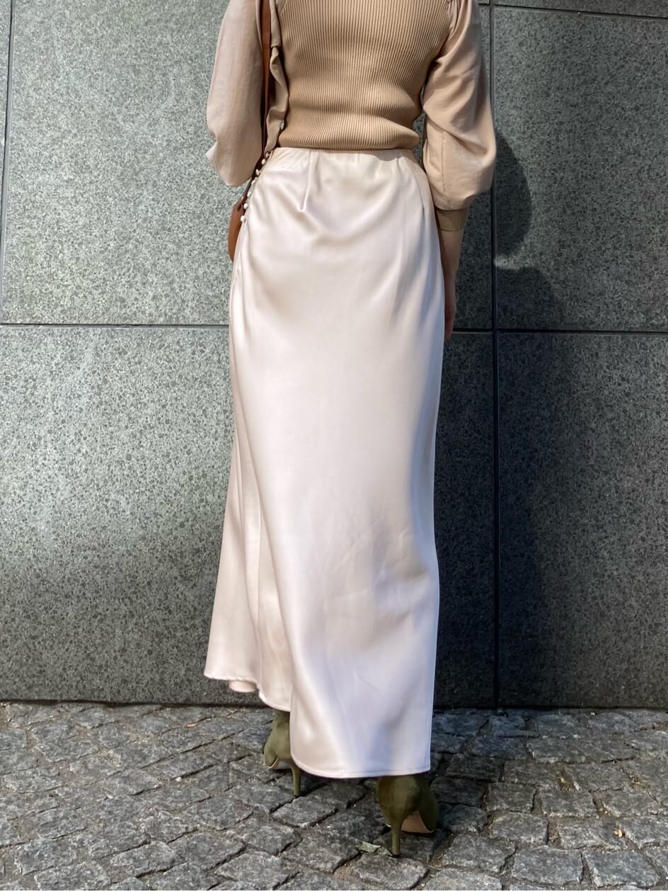 ホワイト系のスカート、ベージュ系のブーツ、ブラウン系のショルダーバッグを着用したレディースの秋コーディネートの7枚目の写真