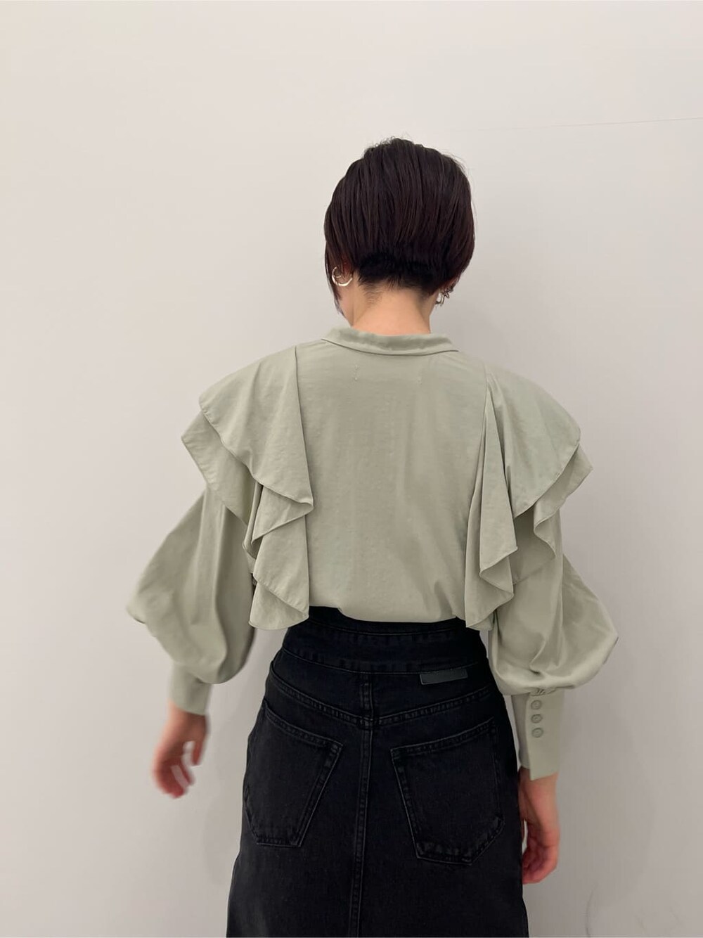 ベージュ系のその他シューズ、ブラック系のデニムスカート、グリーン系のシャツ/ブラウスを着用したレディースの冬コーディネートの6枚目の写真