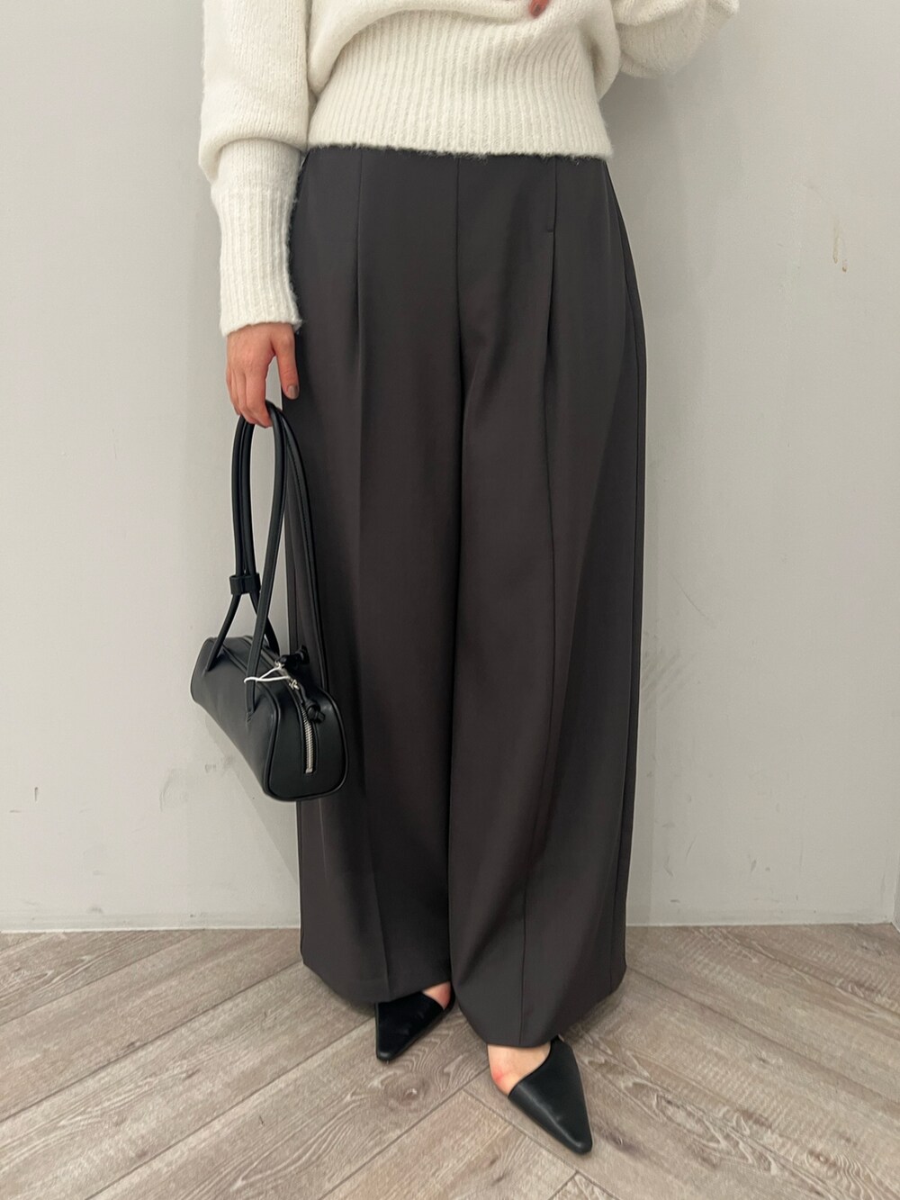 グレー系のその他パンツ、ブラック系のパンプス、ブラック系のショルダーバッグを着用したレディースの冬コーディネートの7枚目の写真