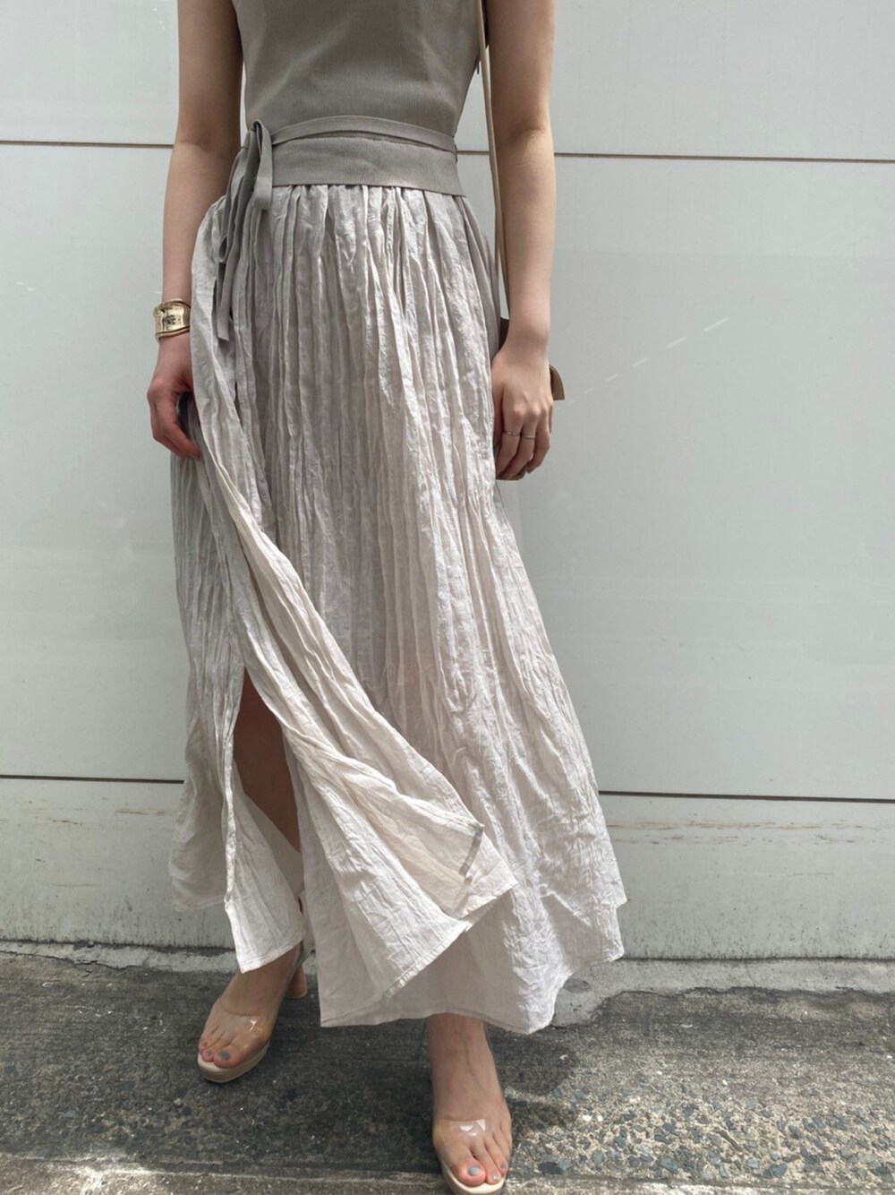 その他のパンプス、ベージュ系のハンドバッグ、グレー系のワンピースを着用したレディースの夏コーディネートの3枚目の写真