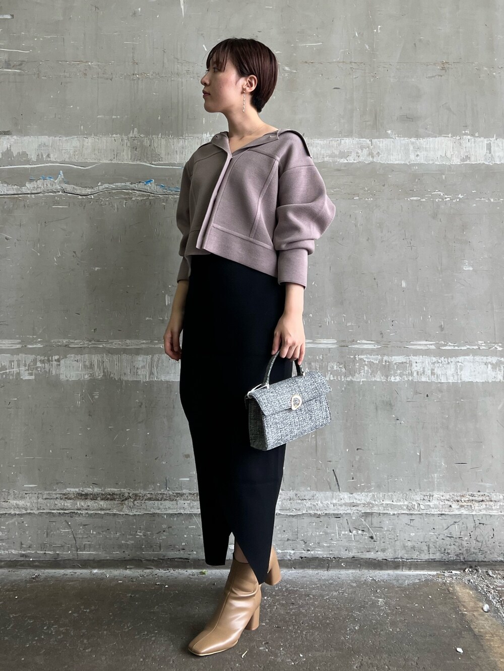 ベージュ系のブーツ、ブラック系のスカート、ベージュ系のカーディガン/ボレロを着用したレディースの秋コーディネートの2枚目の写真