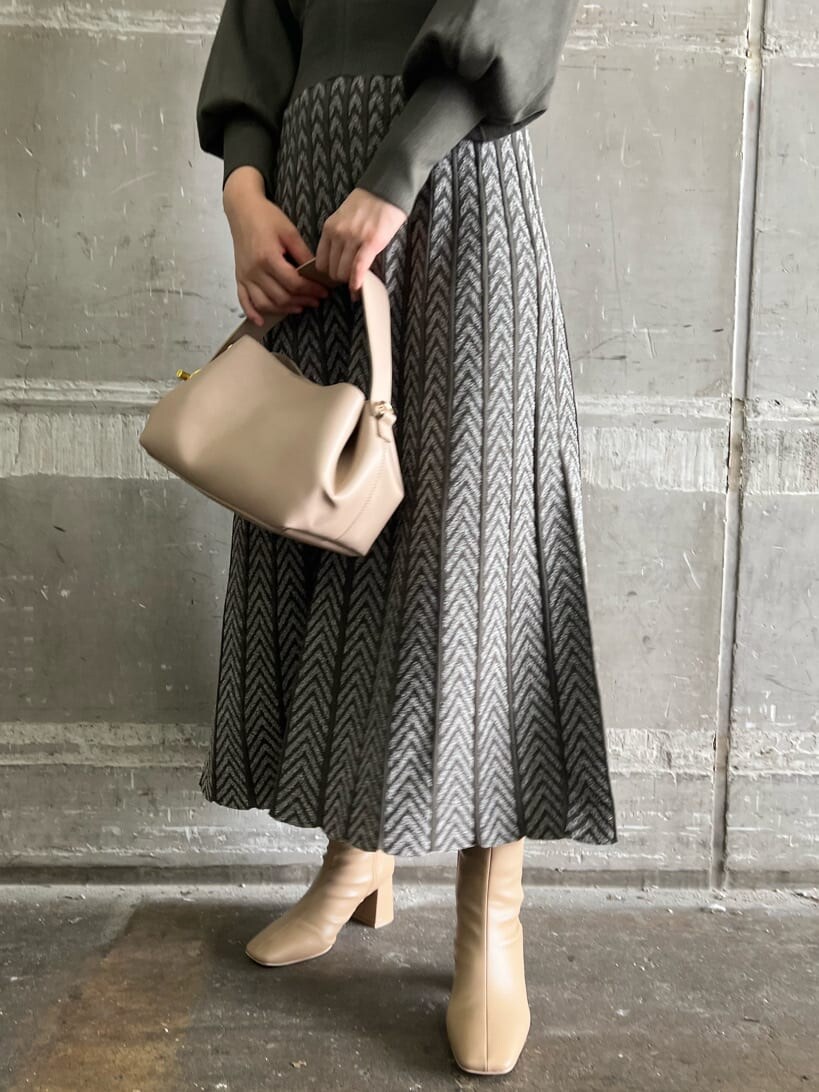 ベージュ系のブーツ、ベージュ系のハンドバッグ、ベージュ系のワンピースを着用したレディースの秋コーディネートの9枚目の写真