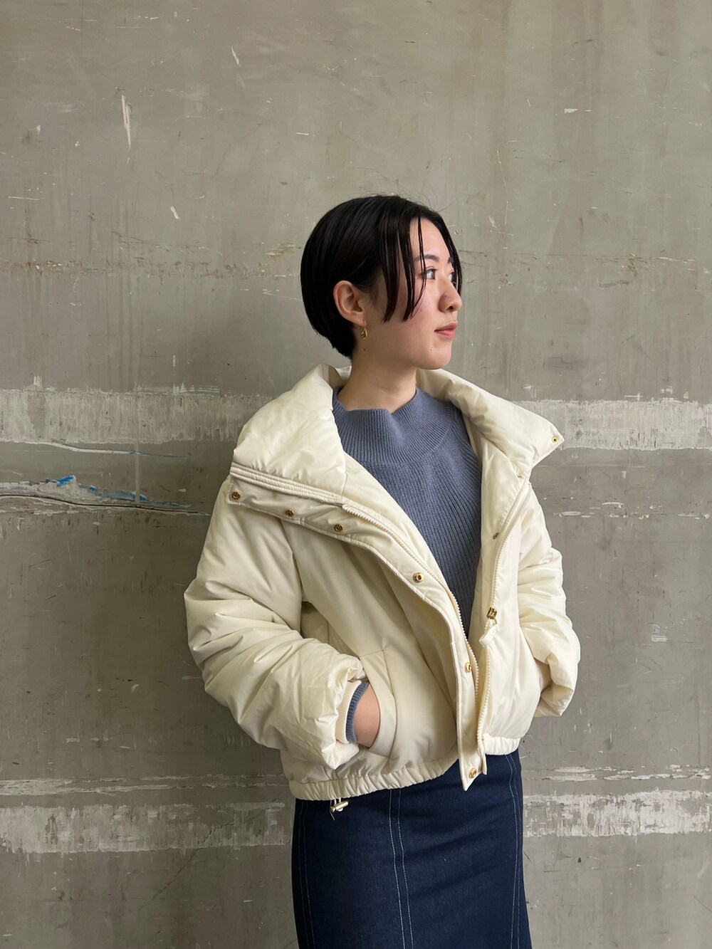 ベージュ系のブーツ、ブルー系のスカート、ホワイト系のダウンジャケット/コートを着用したレディースの冬コーディネートの3枚目の写真