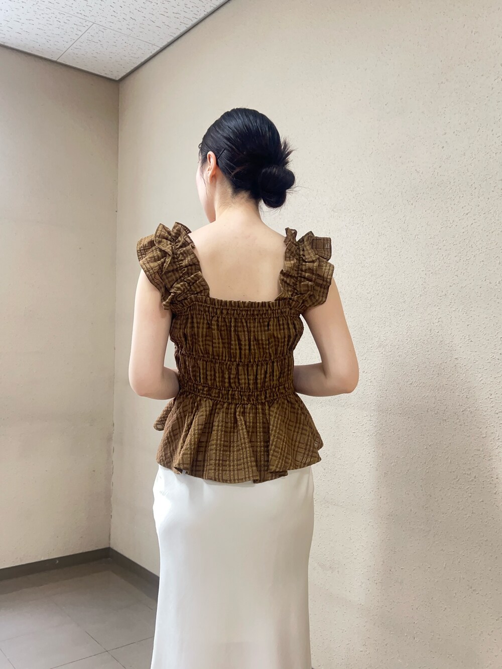 ブラウン系のシャツ/ブラウス、ホワイト系のスカート、ブラウン系のサンダルを着用したレディースの春コーディネートの5枚目の写真