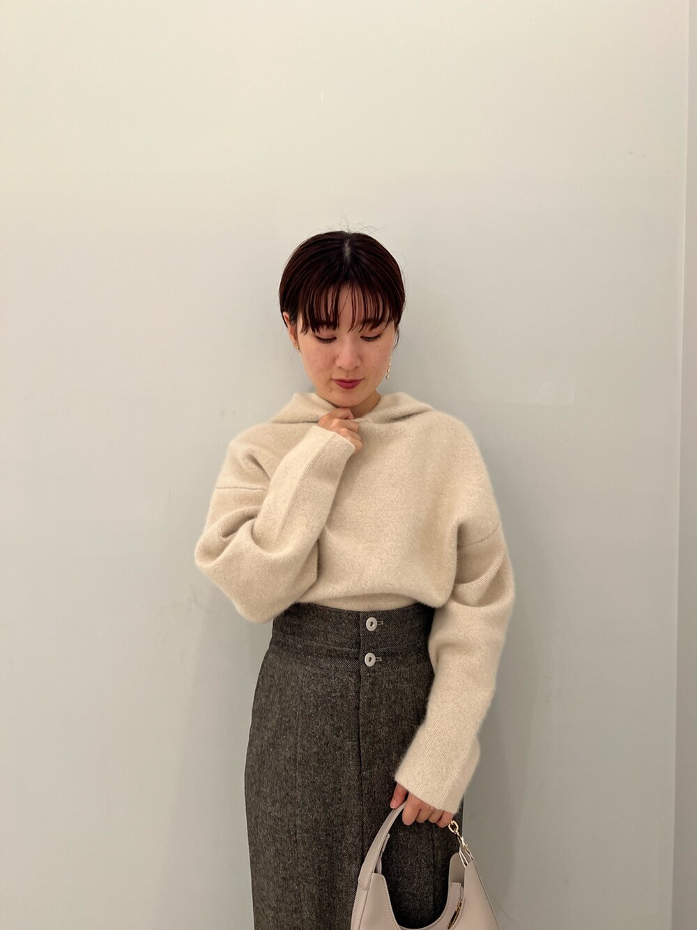 ブラウン系のスカート、ホワイト系のハンドバッグ、ホワイト系のパーカーを着用したレディースの秋コーディネートの4枚目の写真