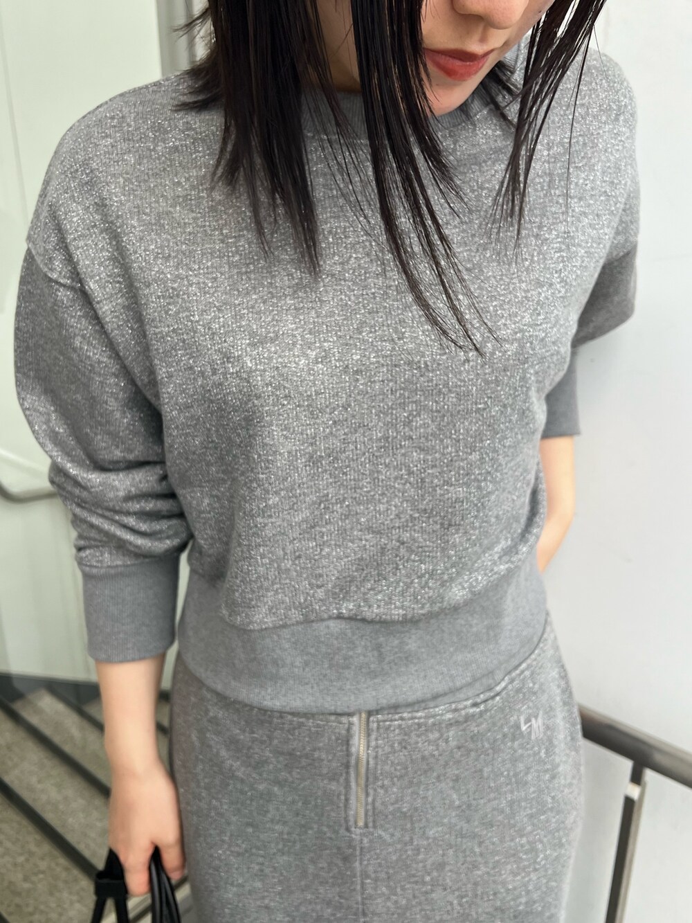 ブラック系のブーツ、グレー系のスカート、グレー系のスウェットを着用したレディースの秋コーディネートの4枚目の写真