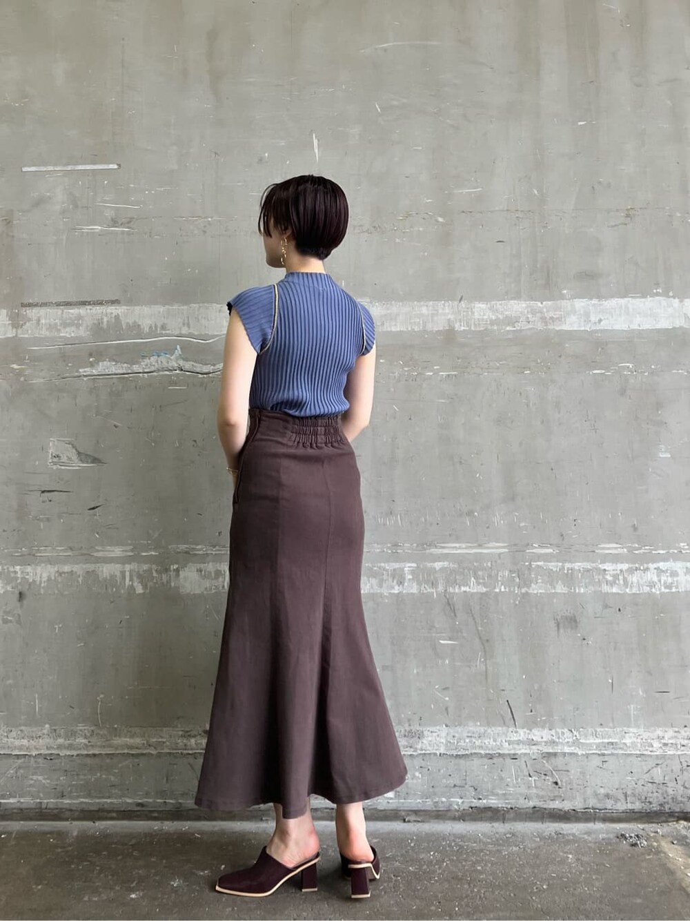 ホワイト系のハンドバッグ、レッド系のサンダル、ブラウン系のスカートを着用したレディースの夏コーディネートの3枚目の写真