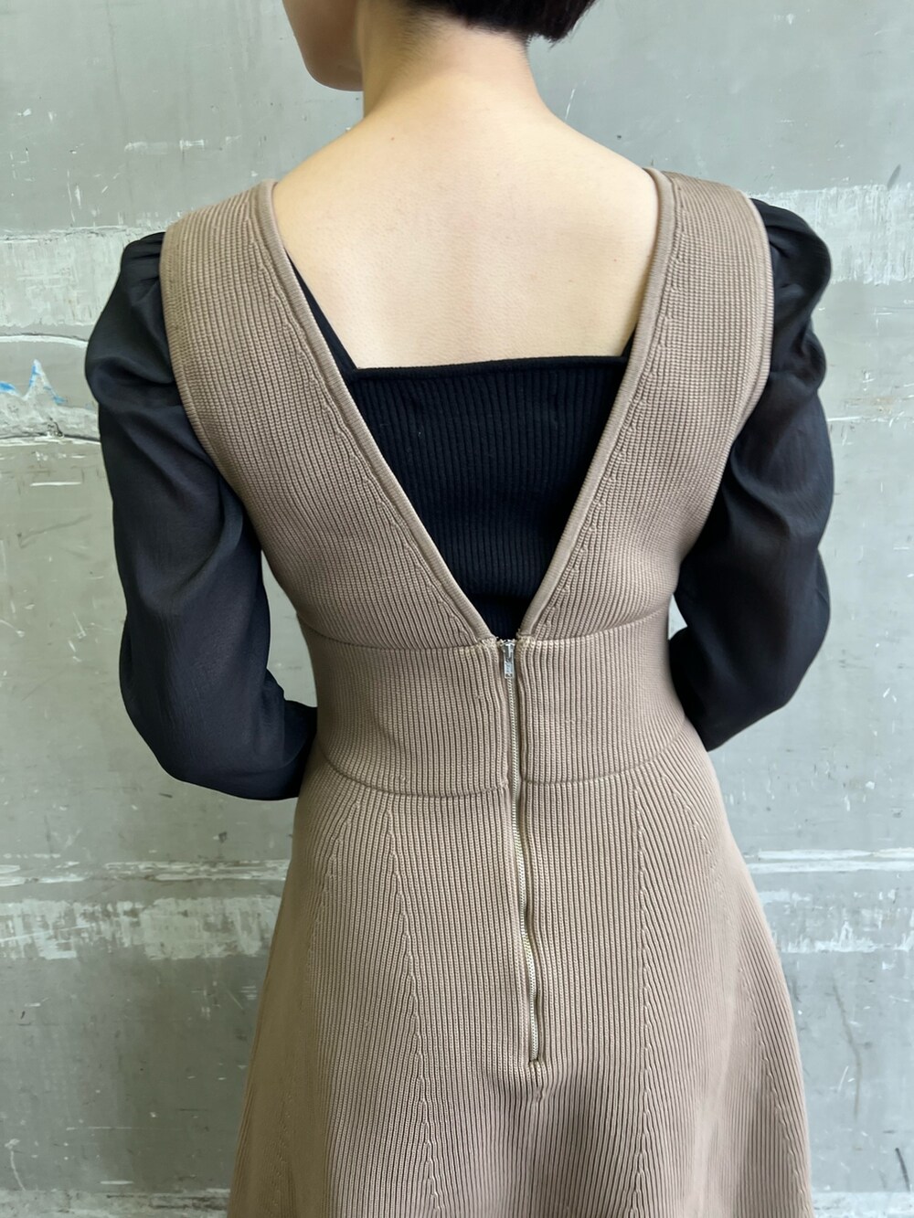 ブラック系のニット/セーター、ホワイト系のショルダーバッグ、ベージュ系のブーツを着用したレディースの冬コーディネートの5枚目の写真