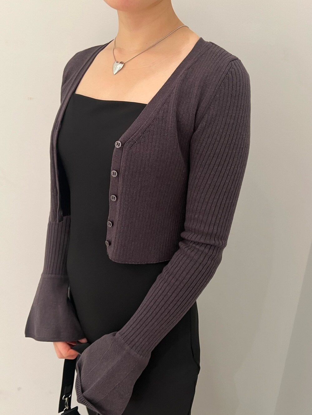 ブラック系のハンドバッグ、シルバー系のパンプス、ブラック系のワンピースを着用したレディースの冬コーディネートの3枚目の写真