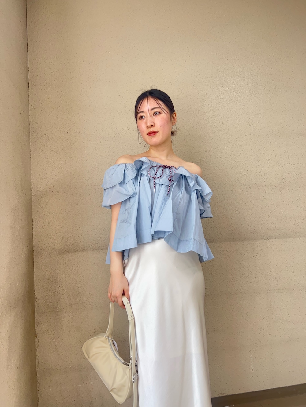 ブルー系のシャツ/ブラウス、ホワイト系のスカート、ブラック系のパンプスを着用したレディースの春コーディネートの3枚目の写真