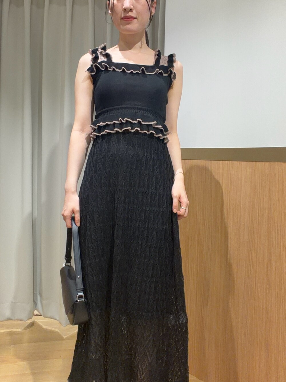 ブラック系のワンピース、ベージュ系のサンダルを着用したレディースの夏コーディネートの3枚目の写真