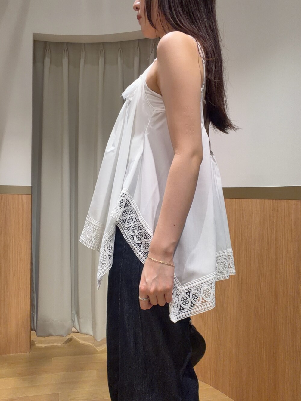 ブルー系のデニムパンツ、ホワイト系のキャミソール、ブラウン系のサンダルを着用したレディースの夏コーディネートの5枚目の写真