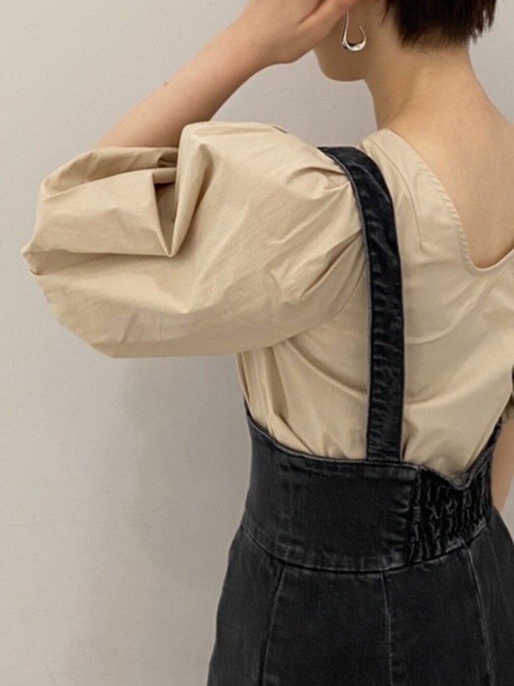 ベージュ系のシャツ/ブラウス、ブラック系のスカート、ベージュ系のブーツを着用したレディースの夏コーディネートの2枚目の写真