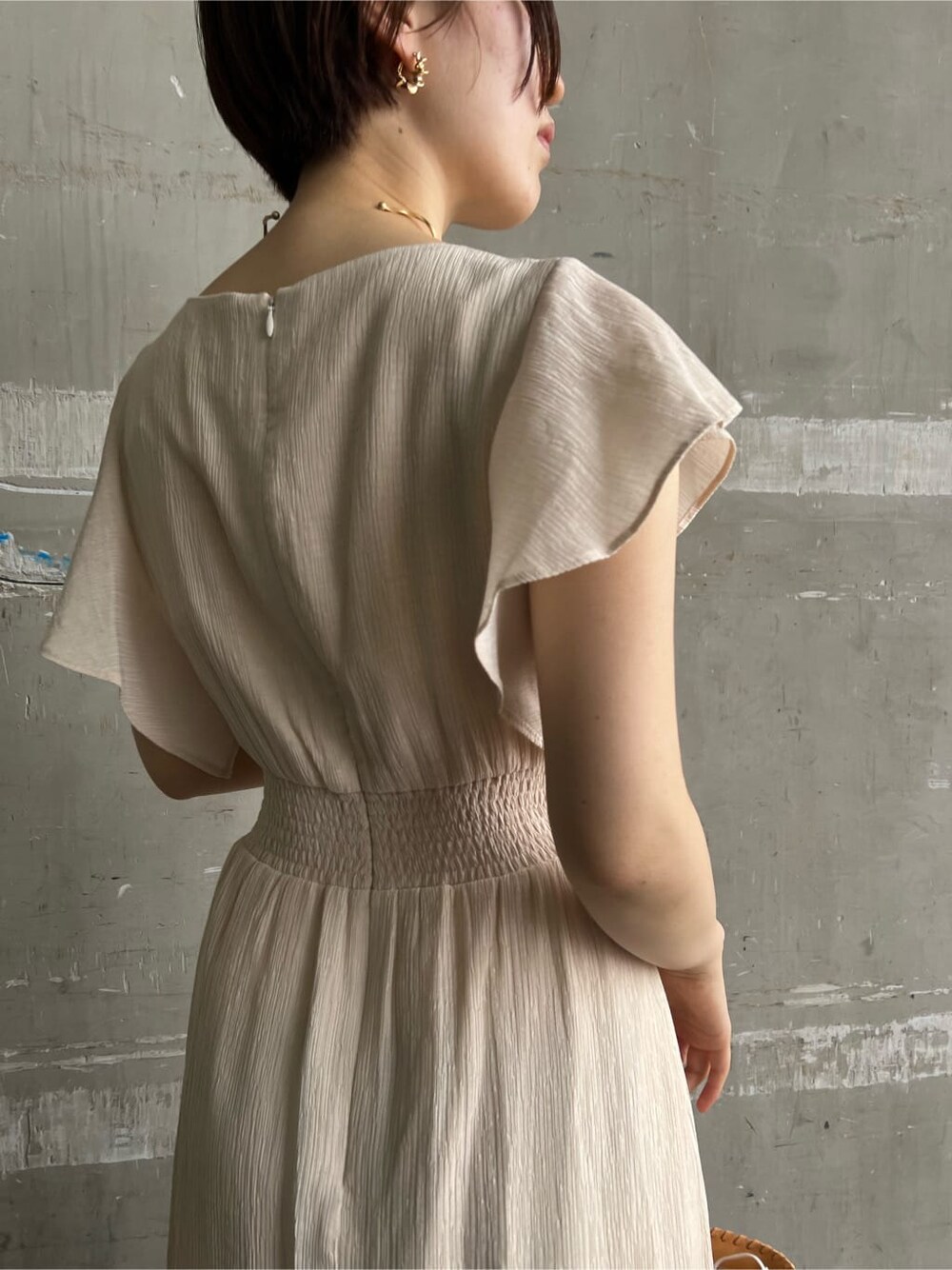 ホワイト系のワンピース、ブラウン系のパンプス、オレンジ系のショルダーバッグを着用したレディースの春コーディネートの8枚目の写真