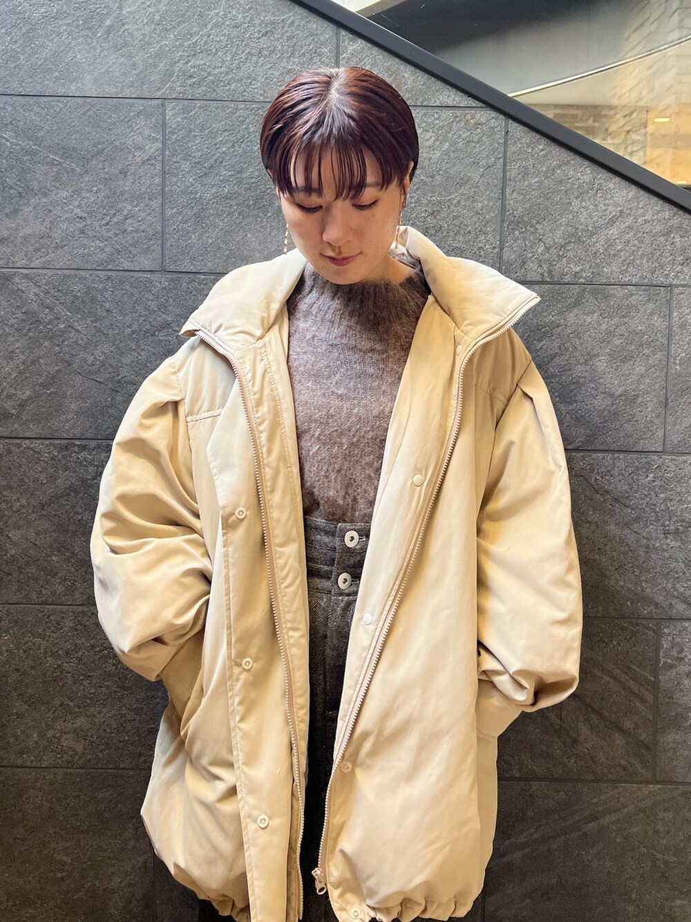 ベージュ系のスニーカー、ブラウン系のスカート、ベージュ系のダウンジャケット/コートを着用したレディースの秋コーディネートの4枚目の写真