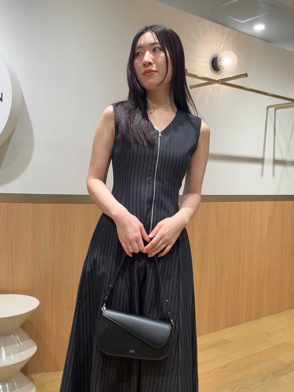 ブラック系のワンピース、ブラック系のハンドバッグ、ブラック系のサンダルを着用したレディースの春コーディネートの3枚目の写真