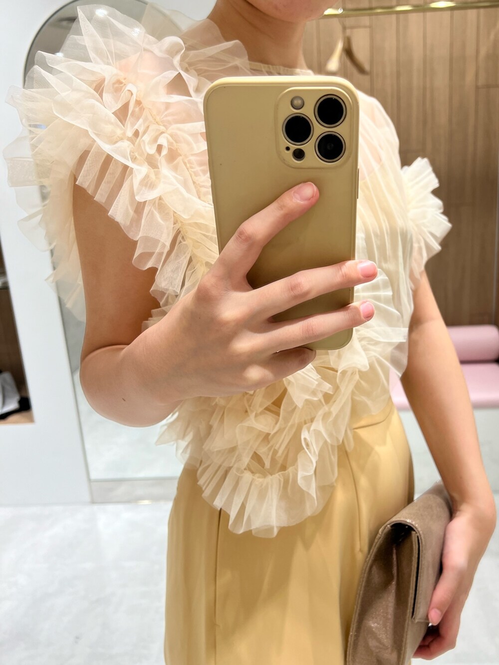 ゴールド系のパンプス、ゴールド系のハンドバッグ、イエロー系のパンツドレスを着用したレディースの秋コーディネートの4枚目の写真