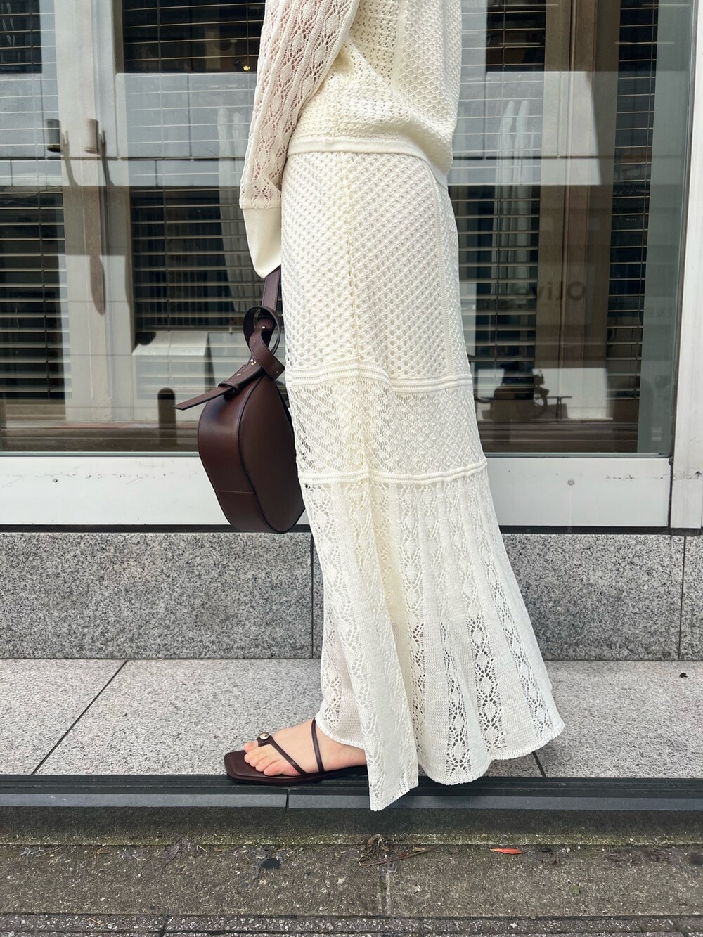 ブラウン系のショルダーバッグ、ホワイト系のカーディガン/ボレロ、ホワイト系のTシャツ/カットソーを着用したレディースの春コーディネートの10枚目の写真