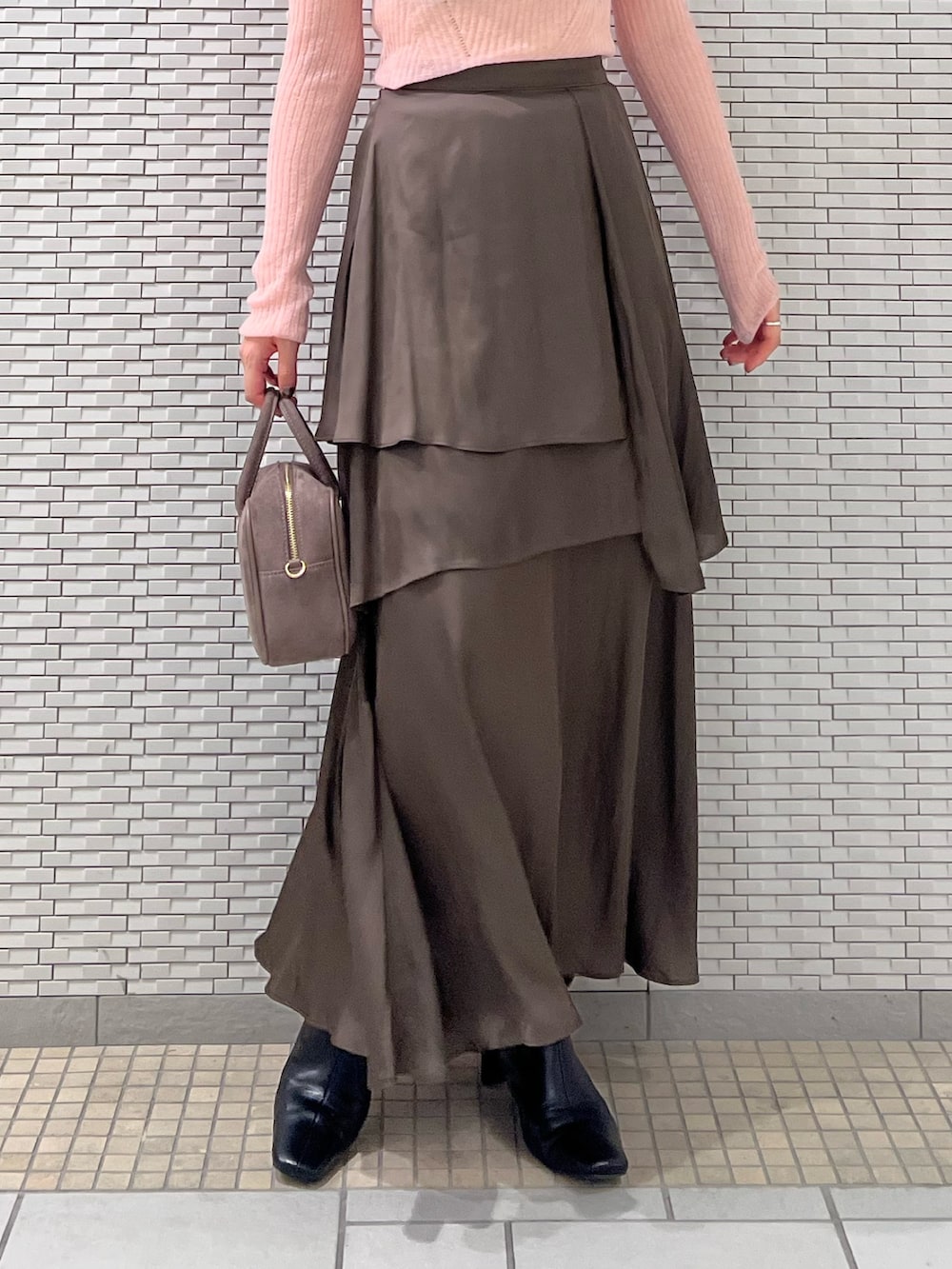 ブラック系のブーツ、ピンク系のニット/セーター、ブラウン系のスカートを着用したレディースの秋コーディネートの5枚目の写真