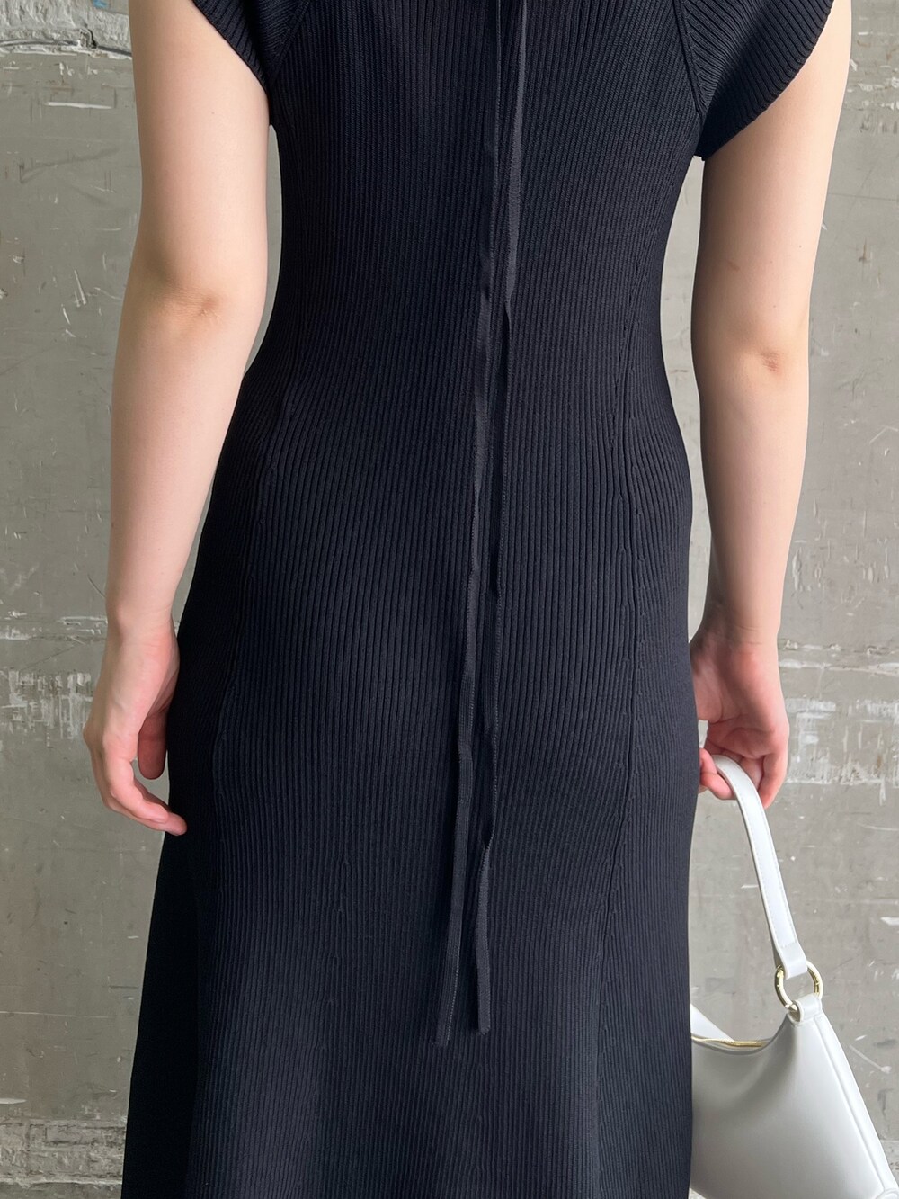 ブラック系のワンピース、ホワイト系のハンドバッグ、ベージュ系のサンダルを着用したレディースの夏コーディネートの9枚目の写真