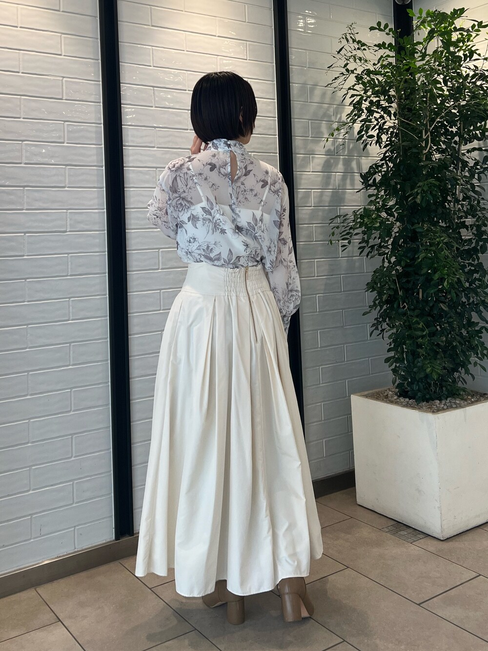 ホワイト系のスカート、ベージュ系のブーツ、ブラウン系のシャツ/ブラウスを着用したレディースの冬コーディネートの5枚目の写真