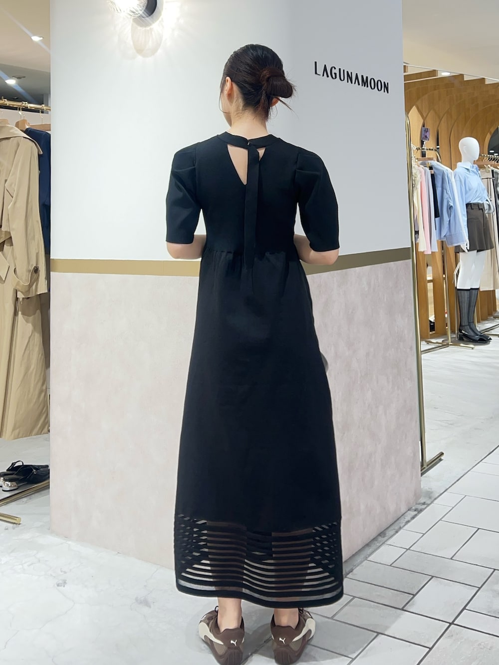 ブラック系のワンピース、ブラウン系のスニーカーを着用したレディースの春コーディネートの3枚目の写真