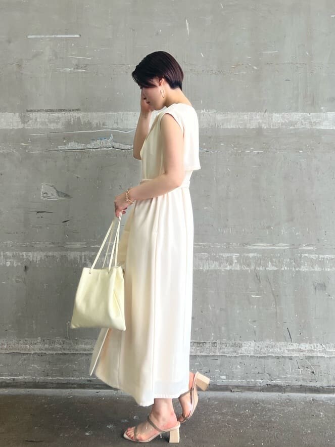 ホワイト系のハンドバッグ、ホワイト系のワンピース、グリーン系のサンダルを着用したレディースの春コーディネートの2枚目の写真