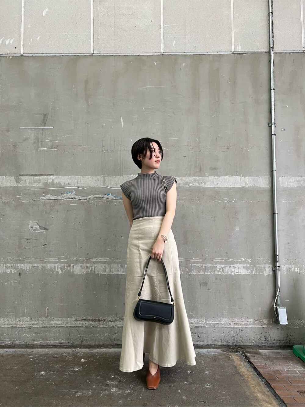 ブラウン系のパンプス、ベージュ系のデニムジャケット、ベージュ系のスカートを着用したレディースの夏コーディネートの4枚目の写真