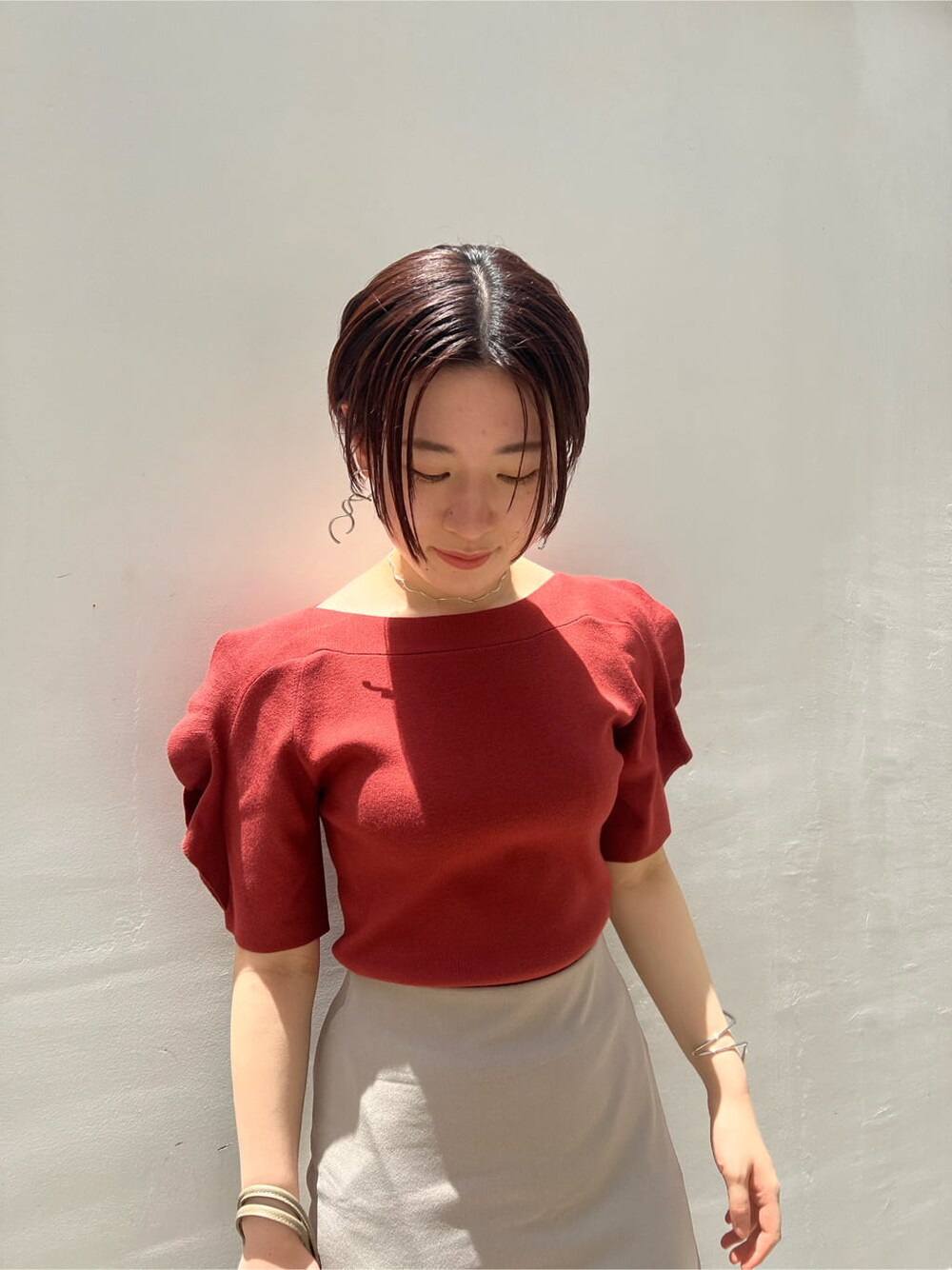 ベージュ系のハンドバッグ、ホワイト系のサンダル、ベージュ系のスカートを着用したレディースの夏コーディネートの6枚目の写真