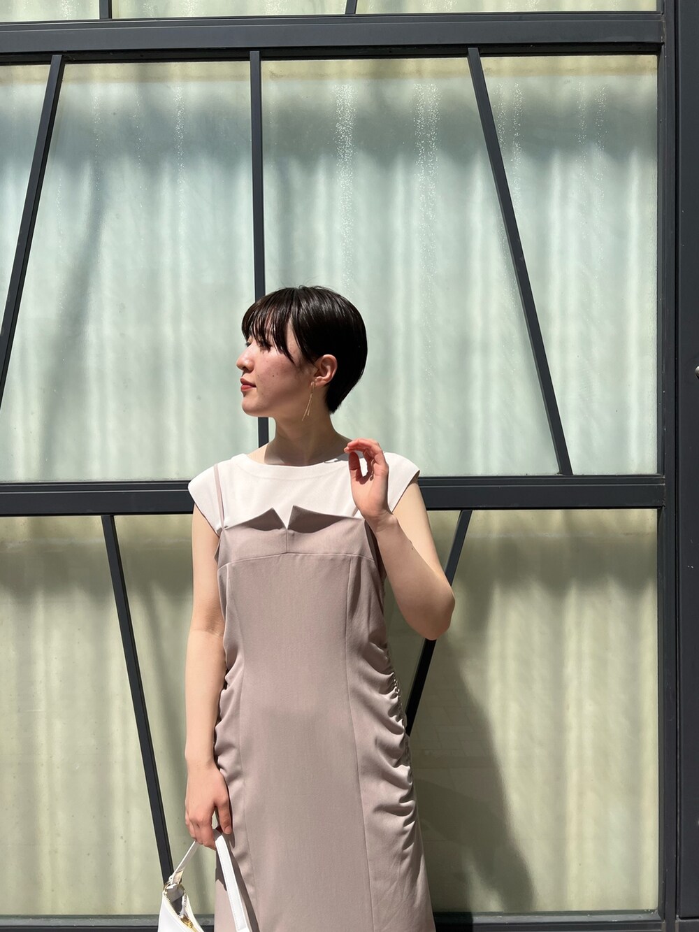 ベージュ系のワンピース、ピンク系のテーラードジャケット、ホワイト系のハンドバッグを着用したレディースの春コーディネートの5枚目の写真